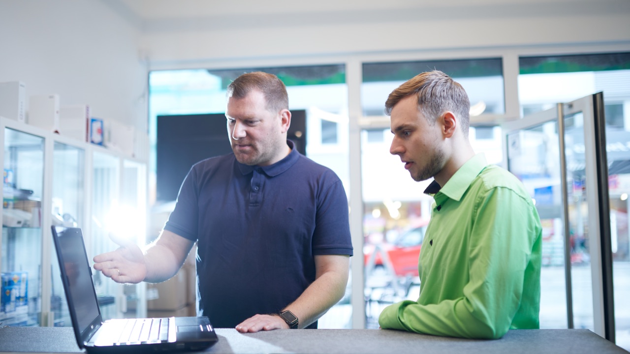 Kunde zeigt unseren Mitarbeiter, Mitarbeiter, ein Problem an seinem Notebook