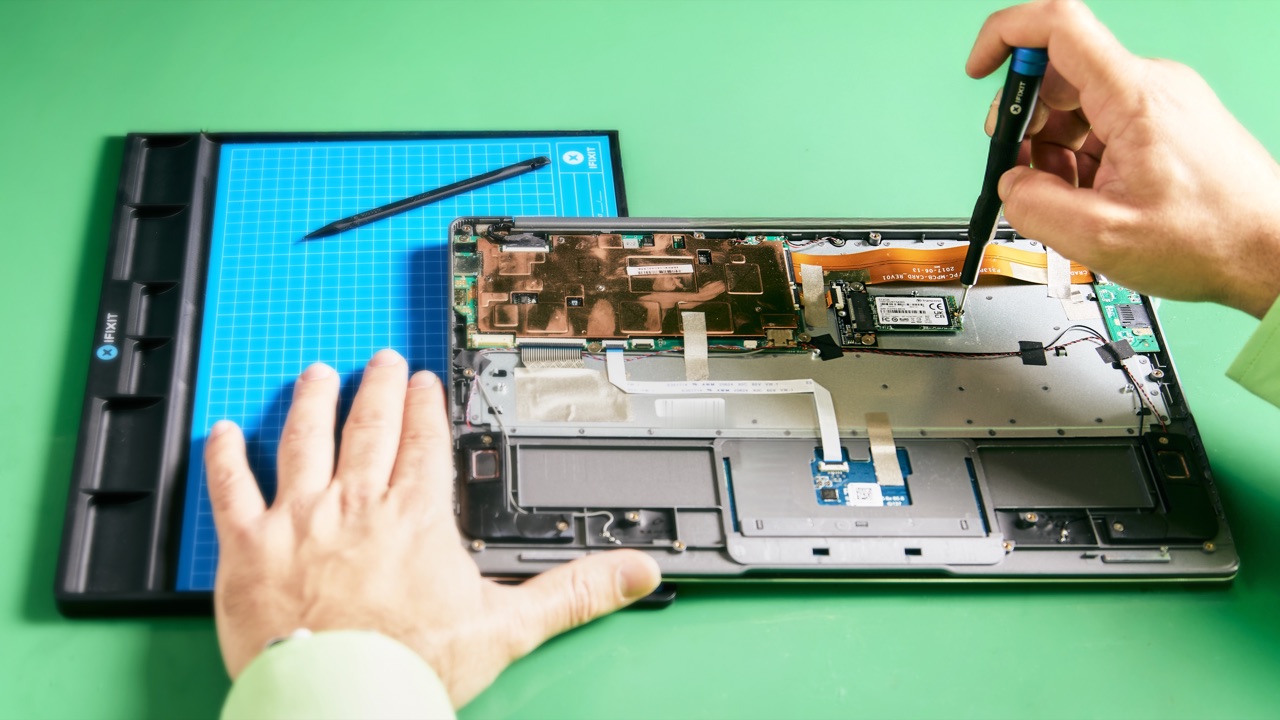 Geöffnetes Notebook auf der Werkbank, Schraubendreher an der SSD